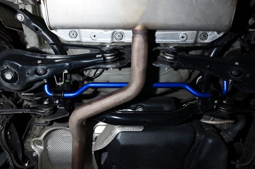 Close-up of a car's undercarriage with suspension components and exhaust system.