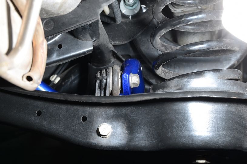 Close-up of a vehicle suspension system with springs and shock absorber.